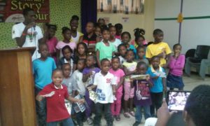 UWI student Delroy Johnson with students visiting the Kingston and St Andrew Parish Library on Saturday, October 15, 2016. The children are learning the Marcus Garvey ABCs from Johnson. ANTHE McGIBBON